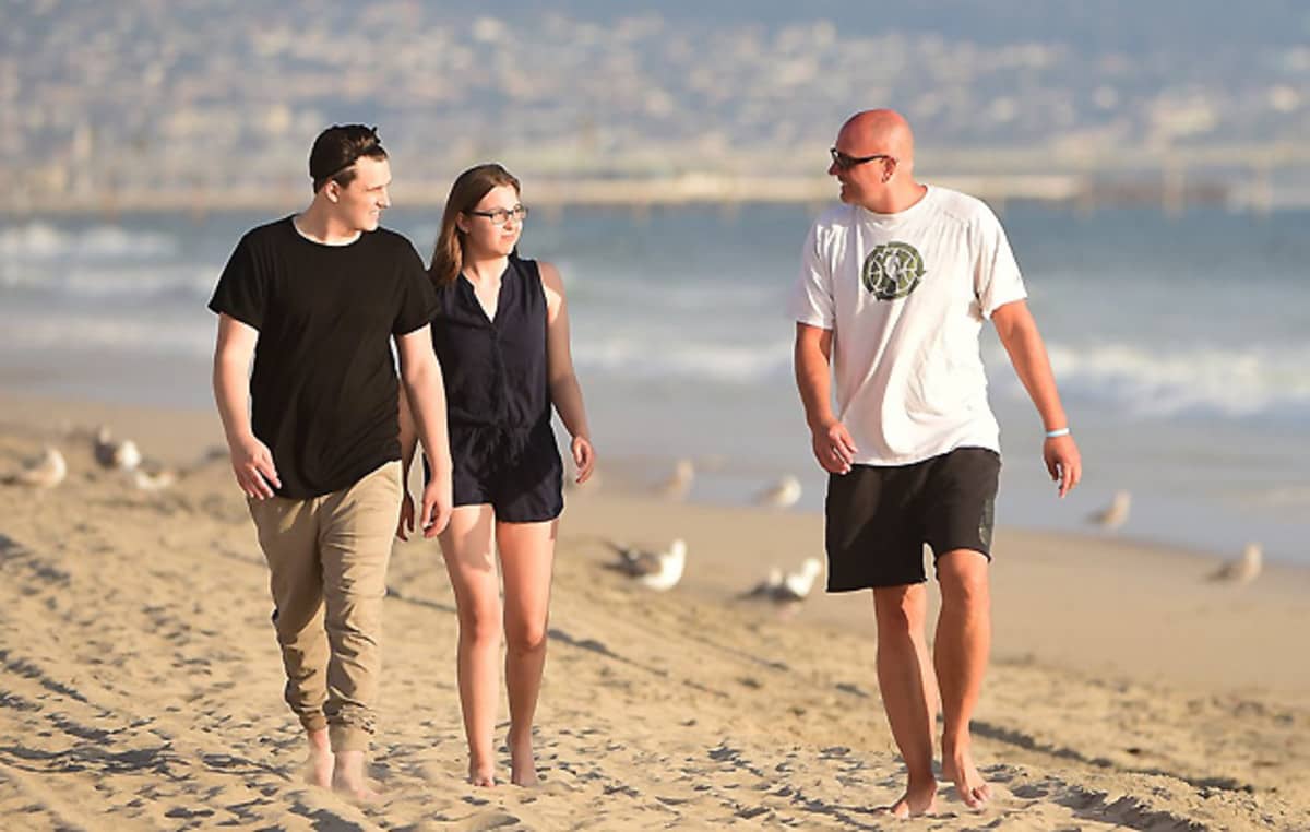 Image of Rex Chapman with his kids in the beach 